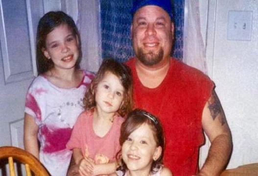 David Silva posing with three of his four children in a family photo
