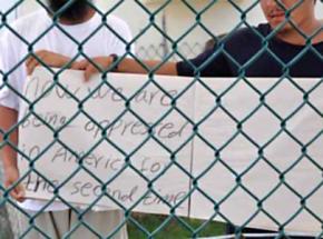 Two Uighur detainees at the Guantánamo prison camp hold a protest in front of visiting journalists