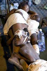 A family shares a single bunk at an overcrowded emergency clinic in Port-au-Prince